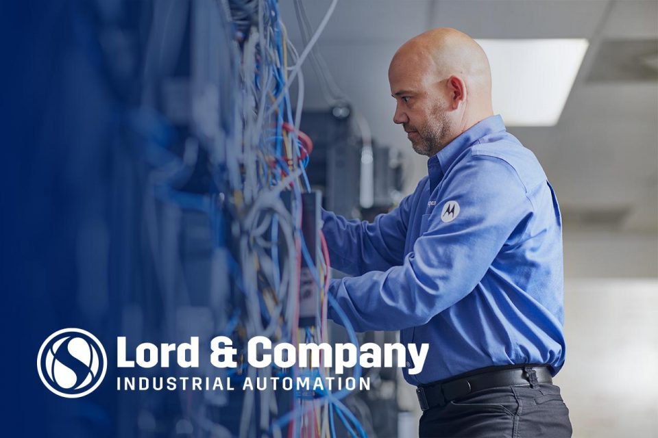 Male employee of Lord & Company adjusting a piece of automation equipment