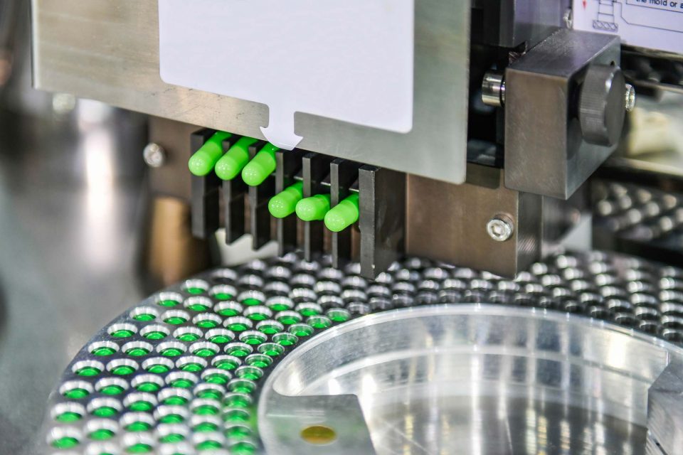 close up of a pharmaceutical production line with small vials being filled