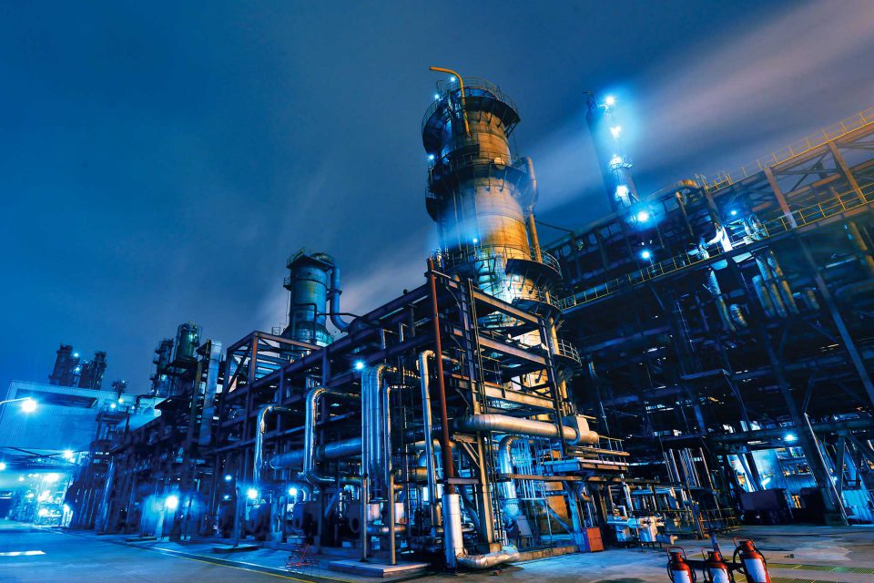 exterior of a chemical plant at night with blue lights