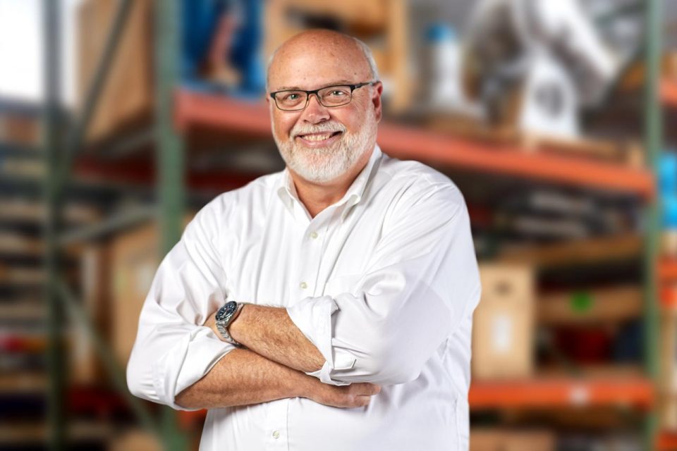 Smiling male MacGuire & Crawford employee wearing a white collared shirt